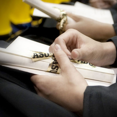 hands holding degree at graduation ceremony
