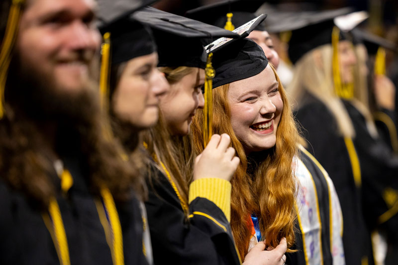 Graduates in cap and gown celebrating.