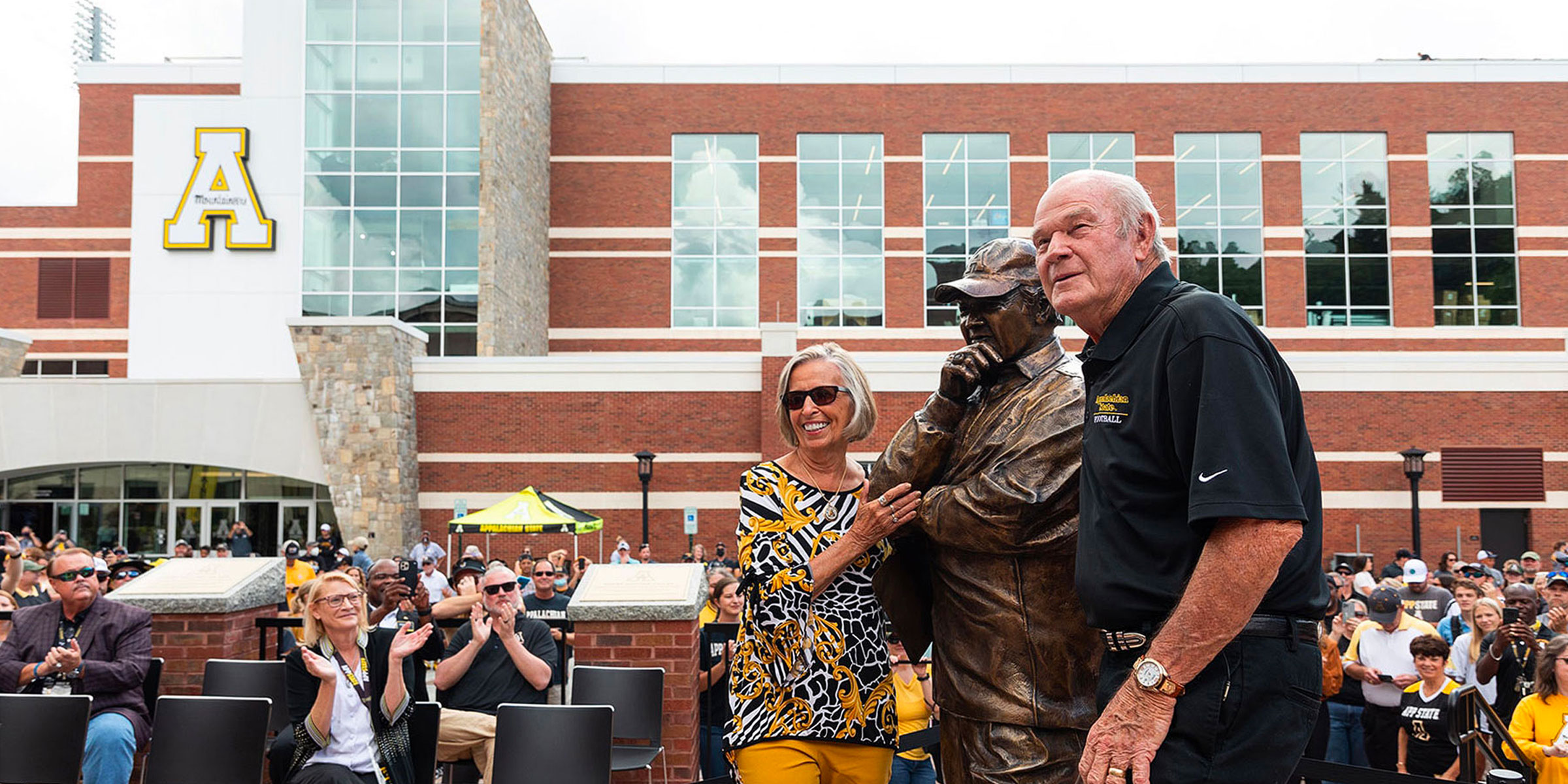 Former head App State football coach Jerry Moore, and his wife, Margaret Moore, are pictured with the bronze statue in his likeness