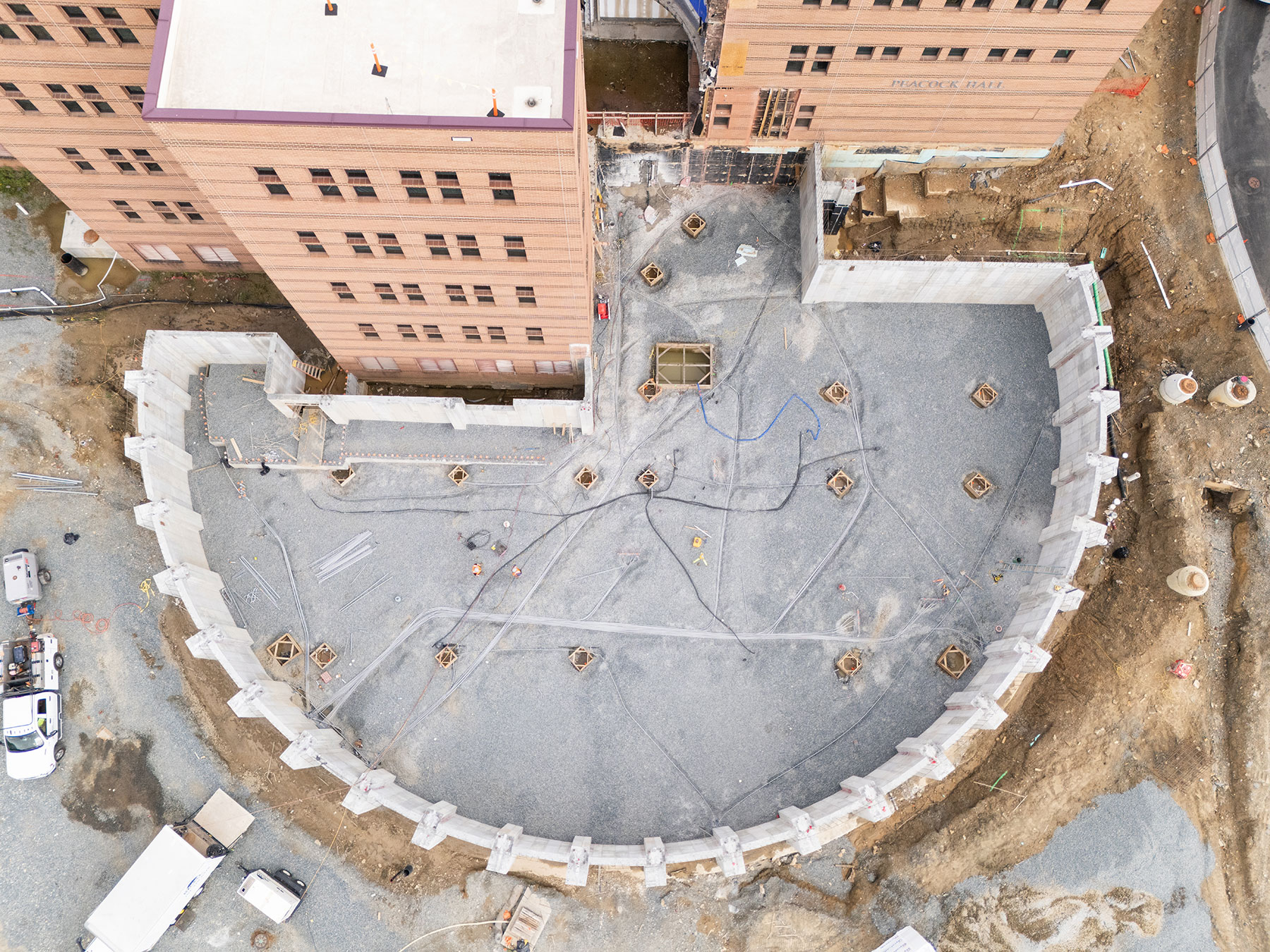 Overhead view of Peacock Hall addition with visible concrete wall and basement utility work.