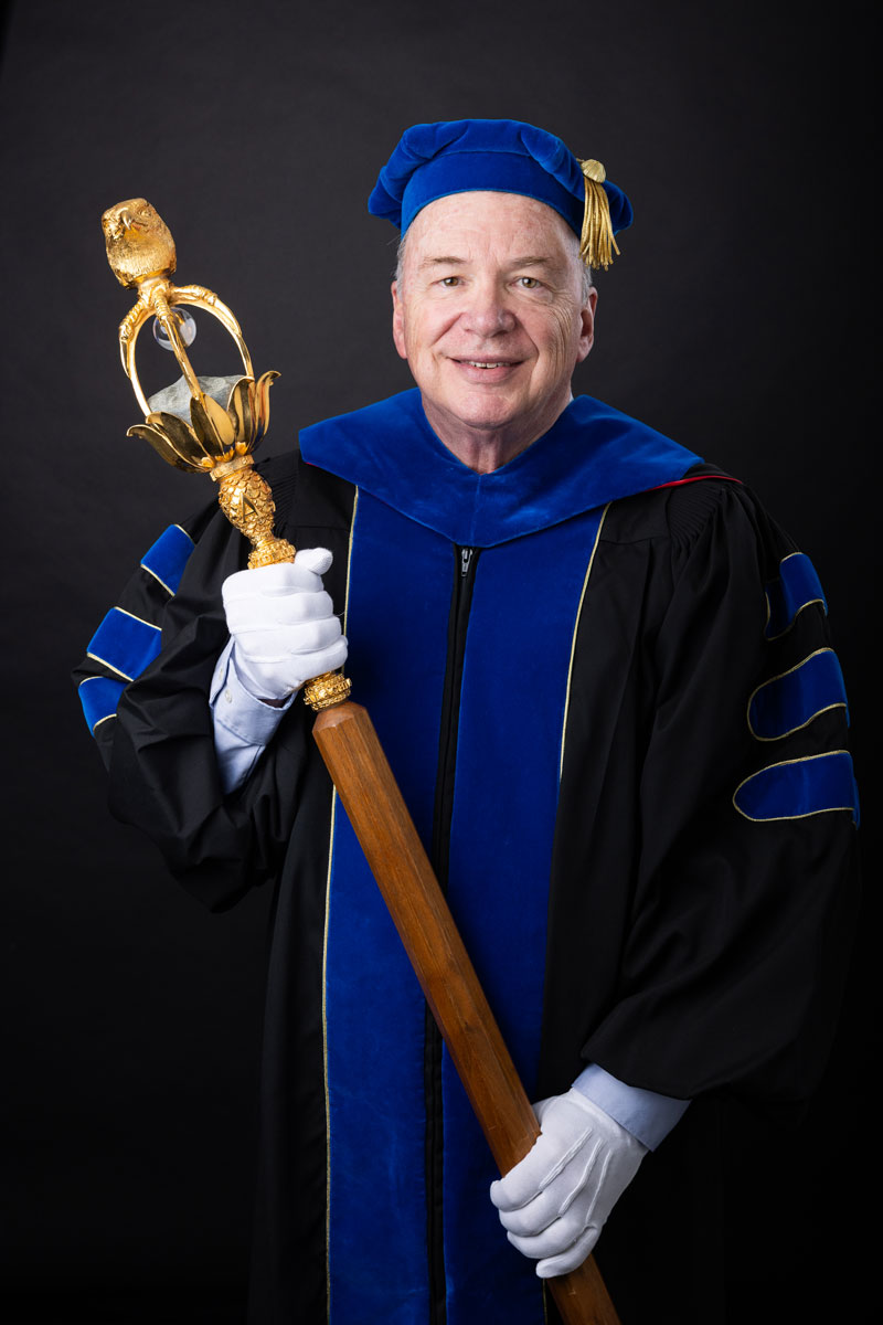 Dr. James Goff holding the university mace.