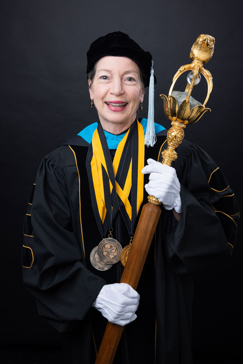 Dr. Marie Hoepfl holding the university mace.