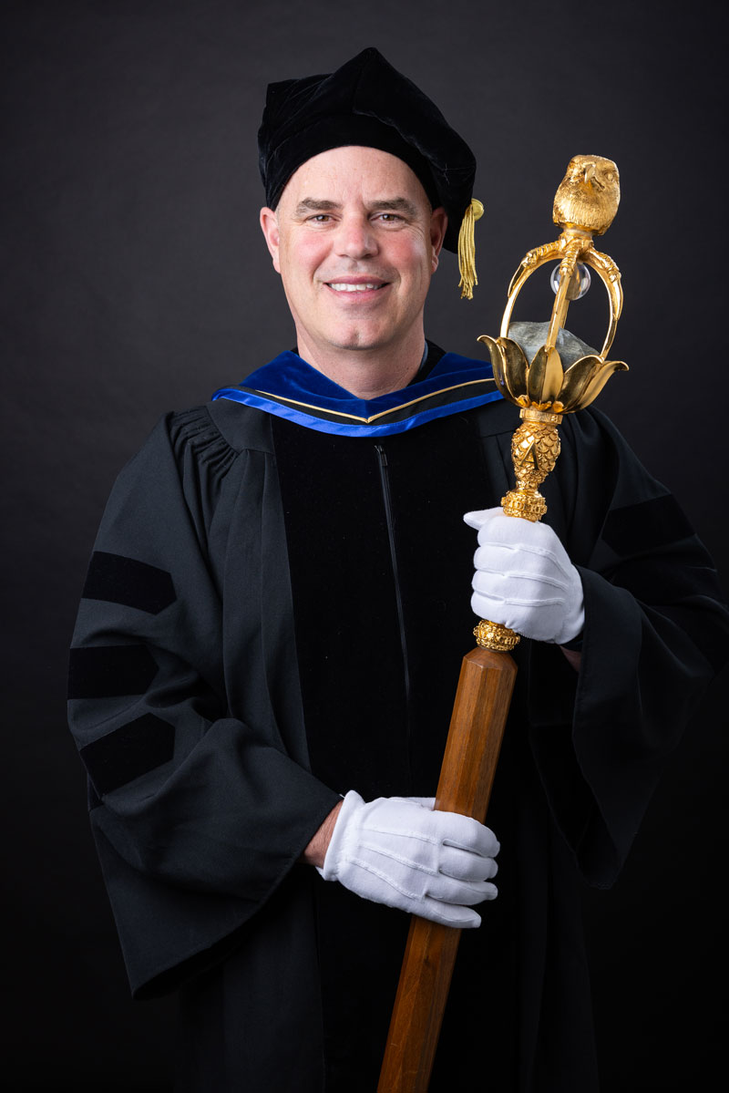 Dr. Mark Lewis holding the university mace.