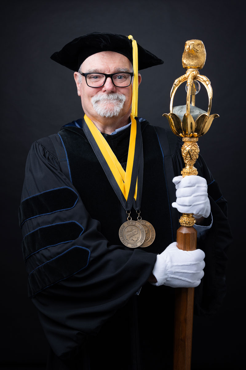 Dr. Steven J. Hageman holding the university mace.